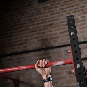 Hands of an athlete gripping a pull-up bar firmly.