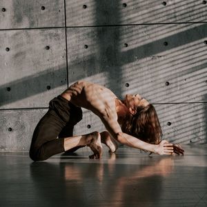 Shadow of an athlete performing movements against a wall.
