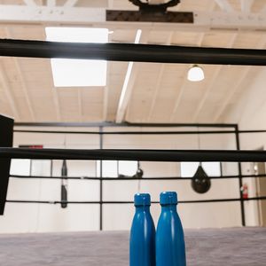 Stylish black reusable water bottle on a gym bench.